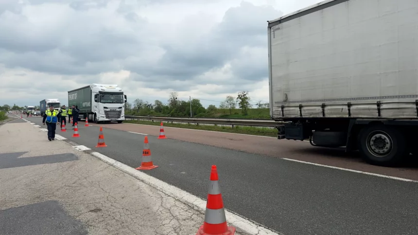 Des policiers le long d'une route avec des camions
