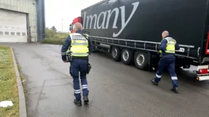 Des agents de la douane marchent a côté d'un camion