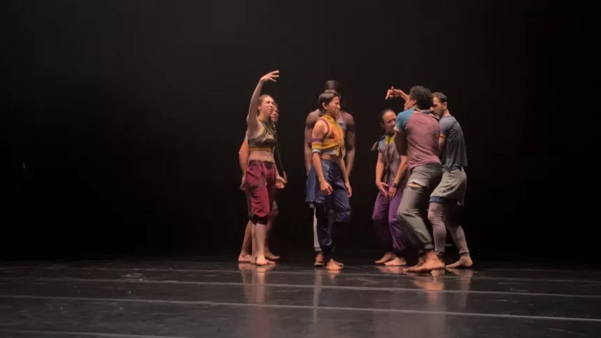 Sept danseurs sur une scène de spectacle noire