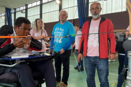 Homme en fauteuil roulant qui fait du tir à l'arc